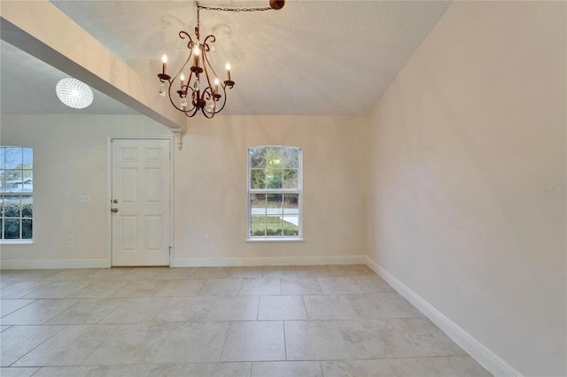 empty room featuring lofted ceiling, light tile patterned flooring, a textured ceiling, a chandelier, and baseboards