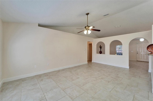 spare room with arched walkways, visible vents, baseboards, vaulted ceiling, and a ceiling fan