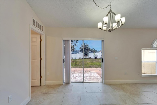 doorway featuring a chandelier, a textured ceiling, light tile patterned flooring, visible vents, and baseboards