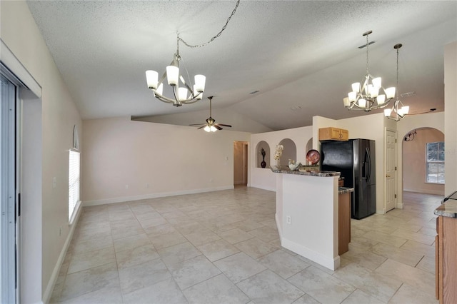 kitchen with arched walkways, lofted ceiling, ceiling fan with notable chandelier, a healthy amount of sunlight, and black fridge