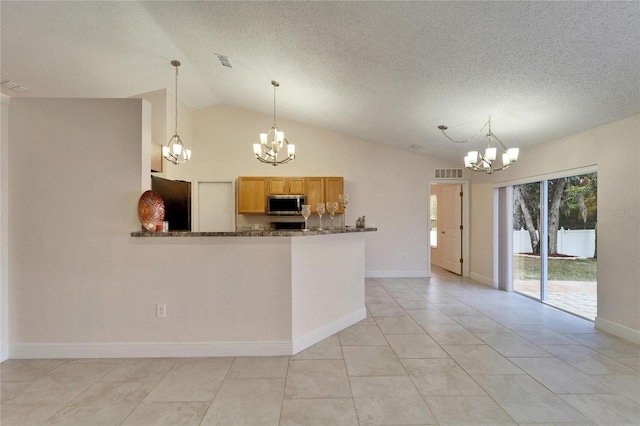 kitchen with a chandelier, freestanding refrigerator, stainless steel microwave, and visible vents