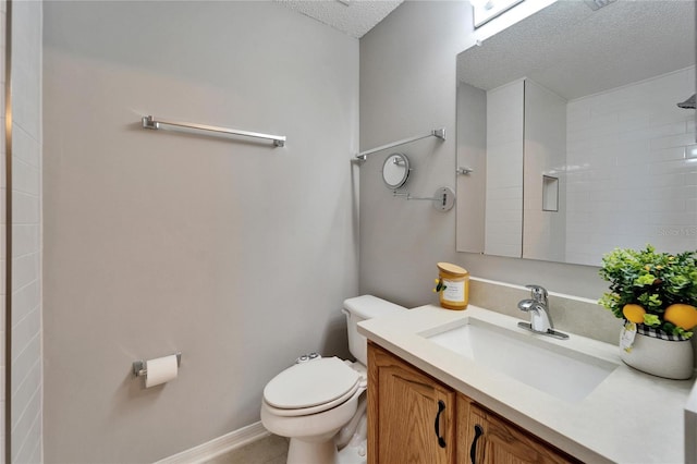 bathroom featuring toilet, baseboards, a textured ceiling, and vanity