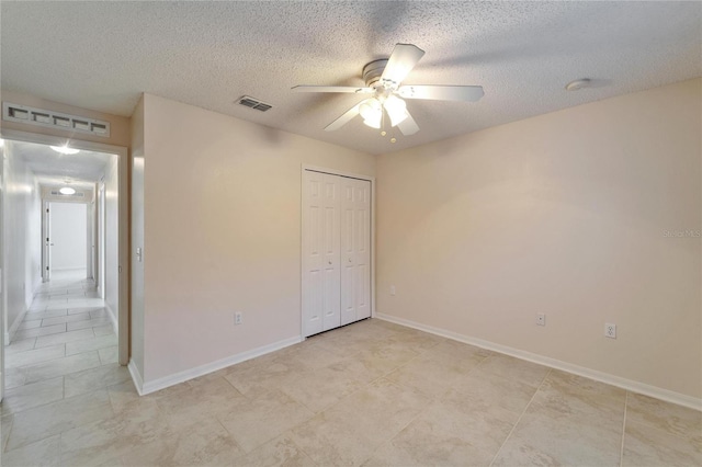 unfurnished bedroom with ceiling fan, a closet, visible vents, and a textured ceiling