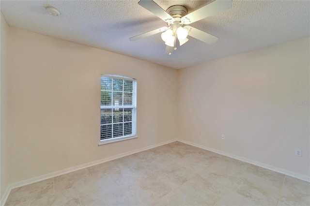 unfurnished room featuring baseboards and a textured ceiling