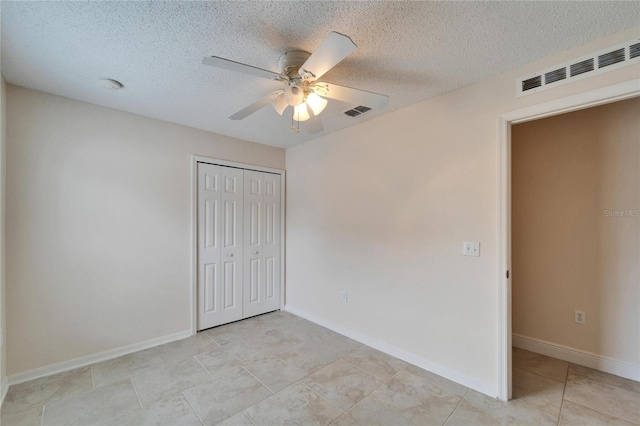 unfurnished bedroom with a textured ceiling, a closet, and visible vents