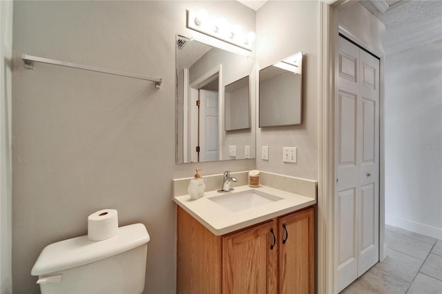 bathroom with toilet, tile patterned flooring, visible vents, and vanity