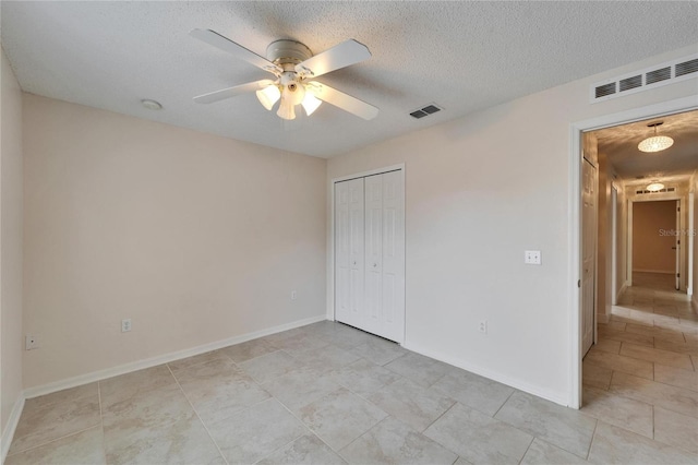 unfurnished bedroom featuring a textured ceiling, ceiling fan, a closet, and visible vents