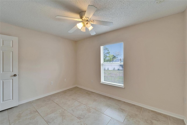 empty room with ceiling fan, baseboards, and a textured ceiling