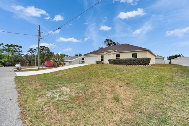 view of front facade with driveway, a garage, fence, a front yard, and stucco siding