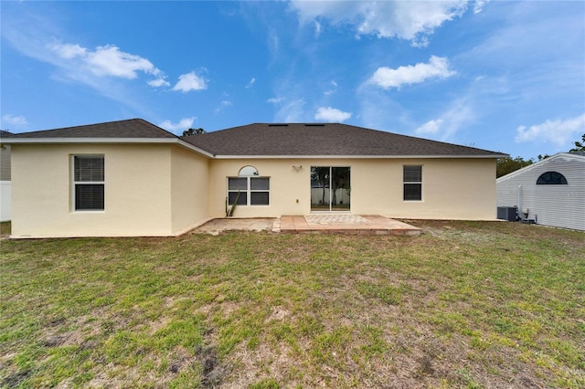 back of house featuring central air condition unit, a yard, stucco siding, and a patio