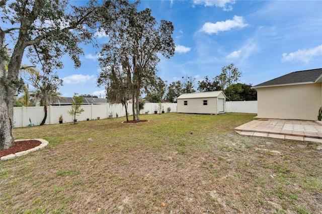 view of yard with an outbuilding, a patio, and a fenced backyard