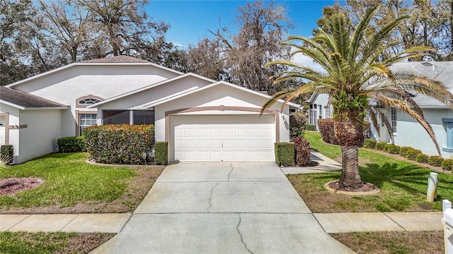 single story home with a front lawn, an attached garage, driveway, and stucco siding