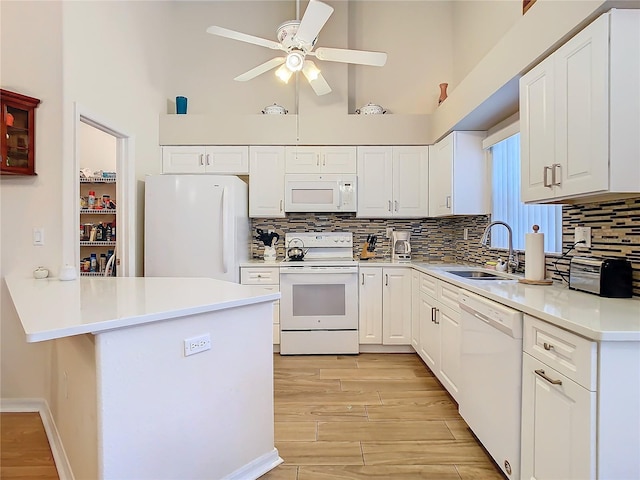 kitchen featuring ceiling fan, white appliances, white cabinets, and a sink