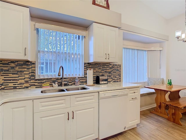 kitchen featuring light wood finished floors, a sink, white cabinets, light countertops, and dishwasher