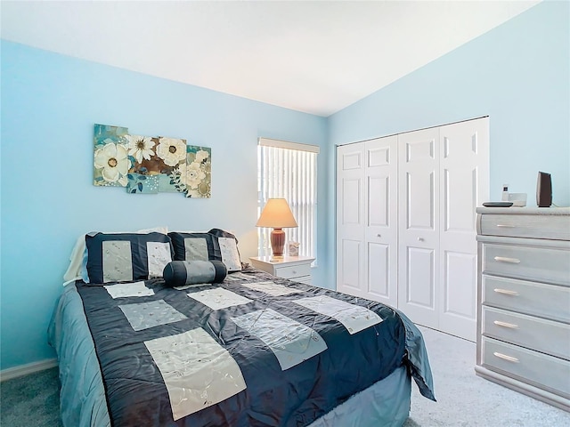 carpeted bedroom with a closet and lofted ceiling