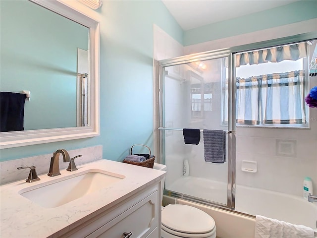 bathroom featuring vanity, toilet, and shower / bath combination with glass door