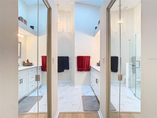 bathroom with baseboards, vanity, marble finish floor, and a shower stall