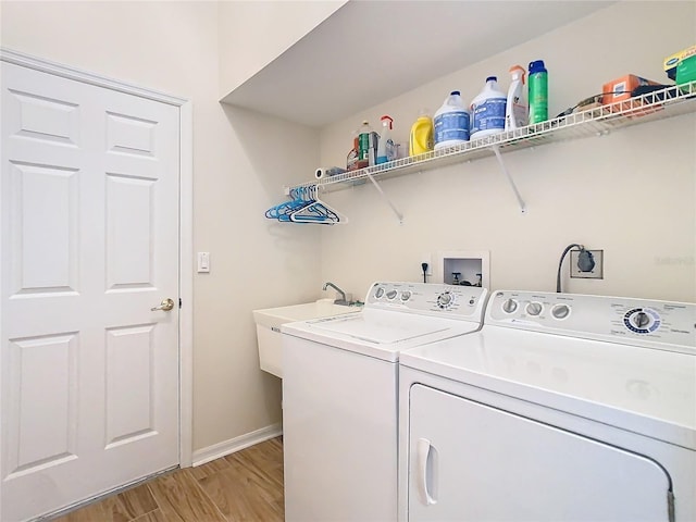 laundry room with washer and dryer, a sink, laundry area, and light wood finished floors