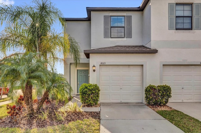 view of front of home with driveway, an attached garage, and stucco siding