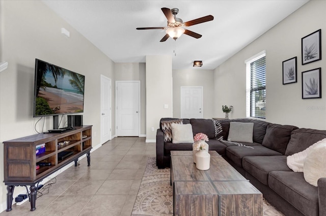 tiled living area featuring a ceiling fan and baseboards