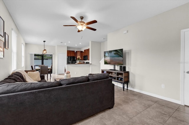 living area featuring a ceiling fan and baseboards