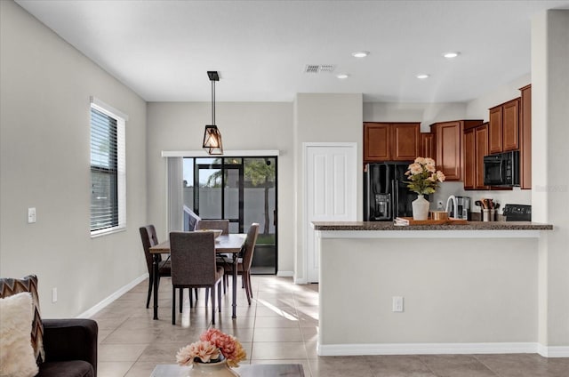 kitchen featuring black appliances, light tile patterned flooring, pendant lighting, and visible vents