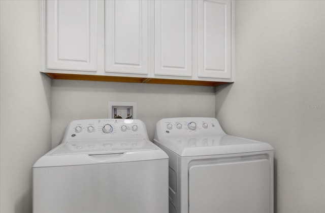 laundry room with washing machine and clothes dryer and cabinet space