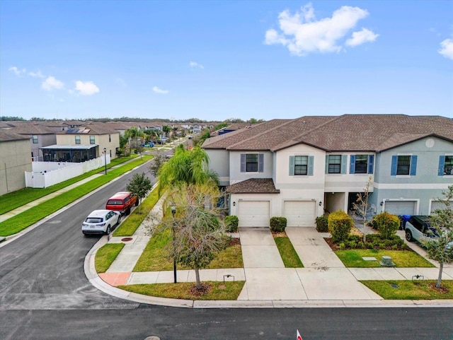 view of front of home featuring a garage, a residential view, driveway, and stucco siding