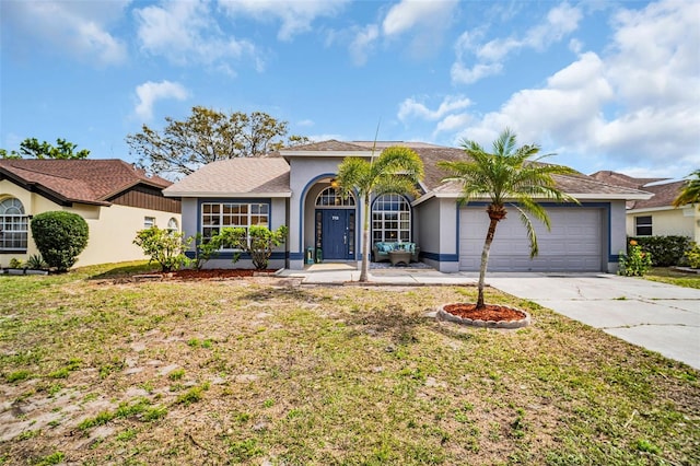 view of front facade with a garage, concrete driveway, a front lawn, and stucco siding