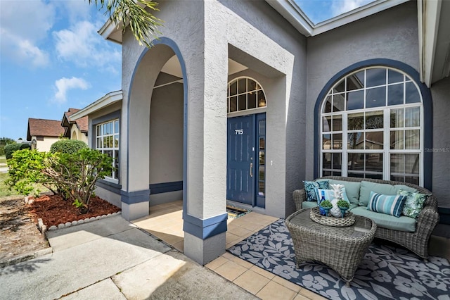 entrance to property featuring an outdoor hangout area and stucco siding