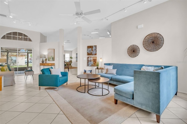 tiled living room featuring a towering ceiling, rail lighting, visible vents, and a ceiling fan