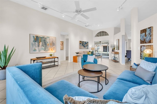 living area featuring light tile patterned floors, visible vents, a ceiling fan, high vaulted ceiling, and track lighting