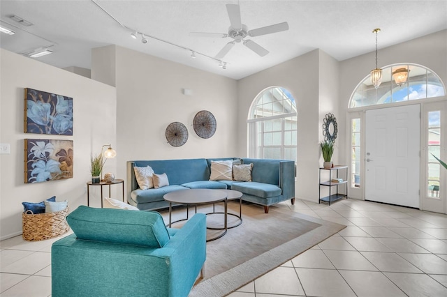 living room featuring a high ceiling, track lighting, and tile patterned floors