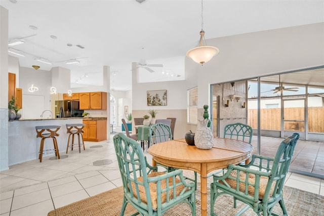 dining room with light tile patterned floors, a high ceiling, and a ceiling fan