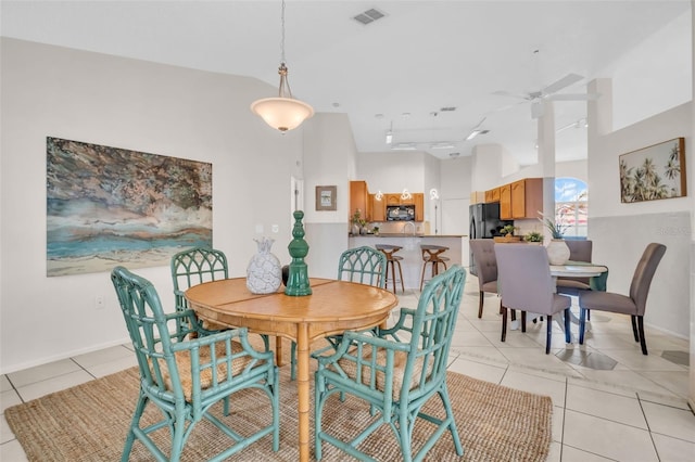 dining space featuring light tile patterned flooring, visible vents, baseboards, vaulted ceiling, and a ceiling fan