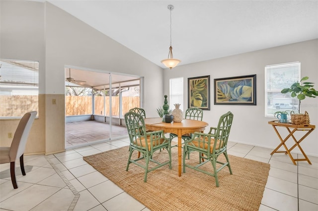 dining space with a wealth of natural light, vaulted ceiling, and light tile patterned floors