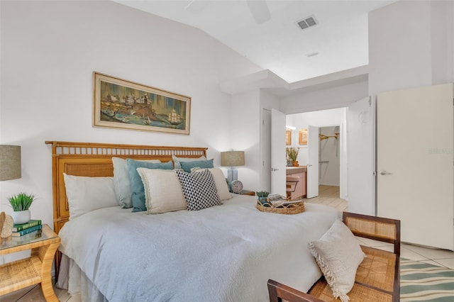 bedroom featuring lofted ceiling, light tile patterned floors, visible vents, and a ceiling fan