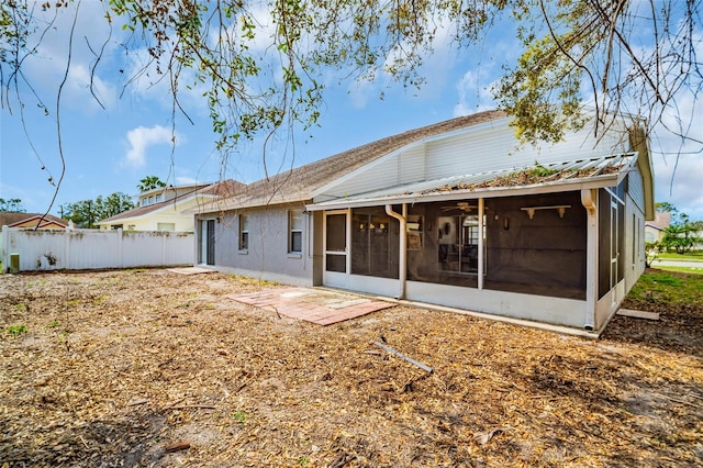 back of property featuring metal roof, fence, and a sunroom