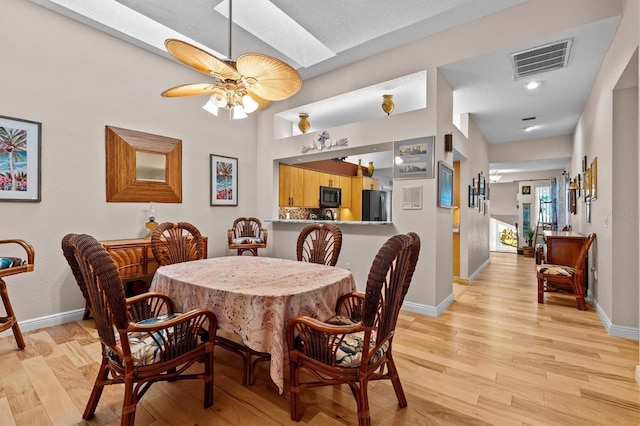 dining area featuring light wood-type flooring, visible vents, and baseboards