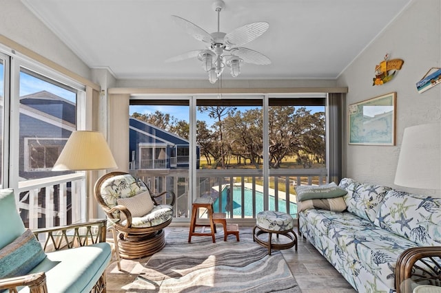 sunroom / solarium featuring a healthy amount of sunlight, vaulted ceiling, and a ceiling fan