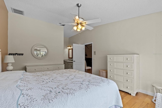 bedroom featuring ceiling fan, a textured ceiling, visible vents, vaulted ceiling, and light wood-type flooring