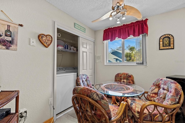 dining space with a ceiling fan, a textured ceiling, and washing machine and clothes dryer