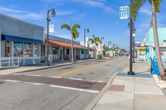 view of road with sidewalks, street lighting, and curbs