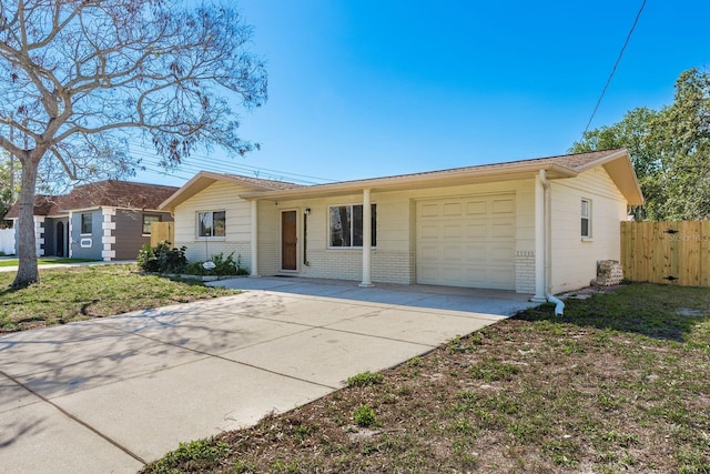 ranch-style home with an attached garage, fence, concrete driveway, and brick siding