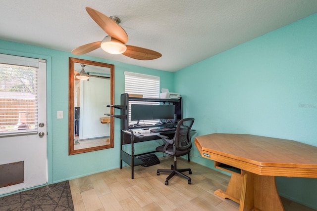 home office featuring a healthy amount of sunlight, a textured ceiling, and wood finished floors