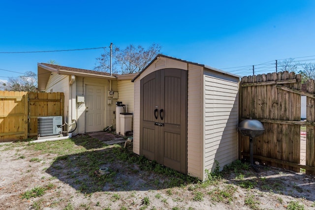 view of shed featuring central AC unit and fence