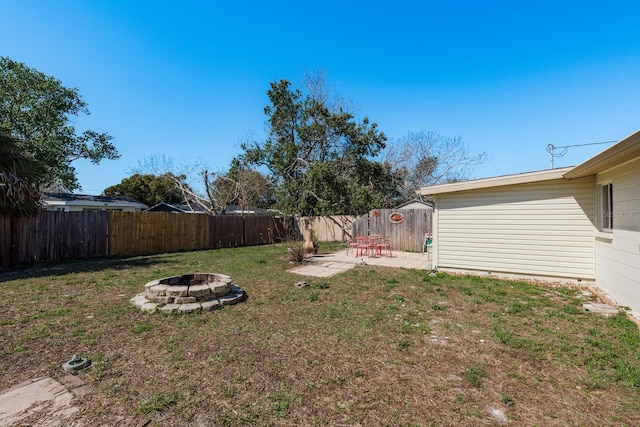 view of yard featuring a fenced backyard, a patio, and a fire pit