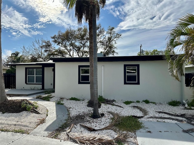 view of front of home featuring fence and stucco siding