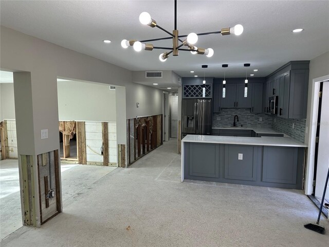 kitchen featuring visible vents, decorative backsplash, stainless steel microwave, black built in fridge, and a sink