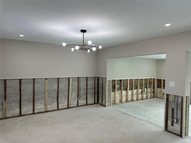 empty room featuring a chandelier and a textured ceiling